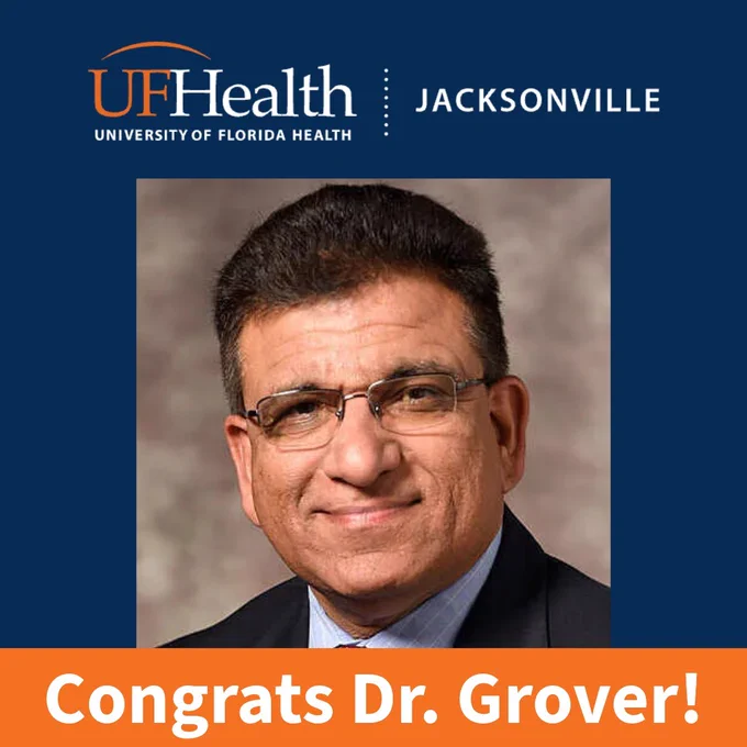 Graphic with a blurred professional headshot centered on an orange background. The top banner reads ‘UF Health University of Florida Health Jacksonville’ in white text on a dark blue bar. A dark blue bar at the bottom reads ‘Congrats Dr. Grover!’ in large white letters.