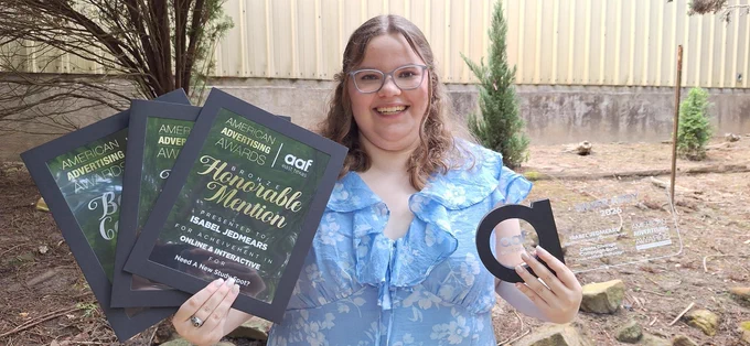  Isabel Jedmears holding up her awards for her advertising campaign.