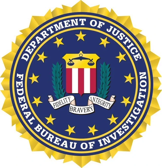 Seal of the FBI featuring a shield with scales, surrounded by stars and a banner reading Fidelity, Bravery, Integrity.