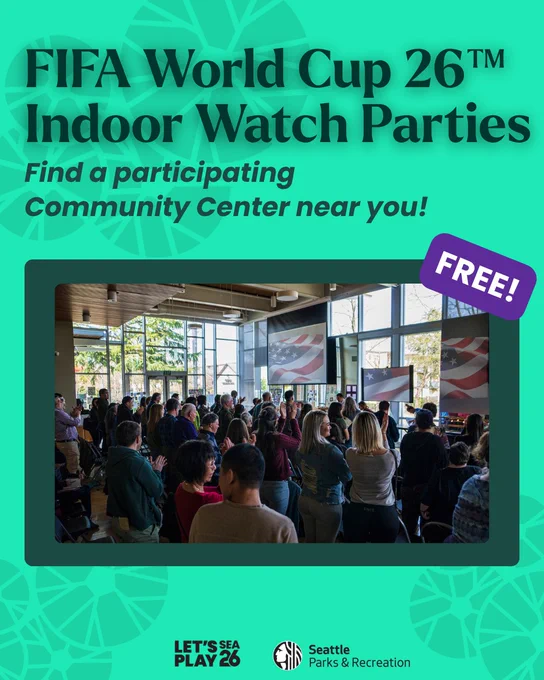 Crowd gathered indoors at a community center watching FIFA World Cup 26 on large screens during a free watch party event.
