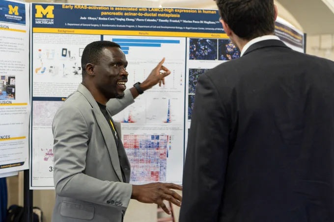 Dr. Jude Okoye talks to an attendee about his research poster.
