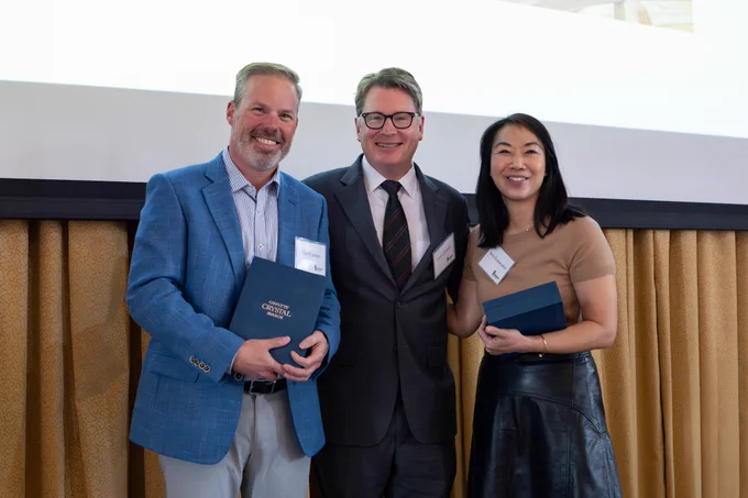 Dr. Timothy Frankel and Dr. Amy Suwanabol pose with Dr. Justin Dimick holding award plaques. 
