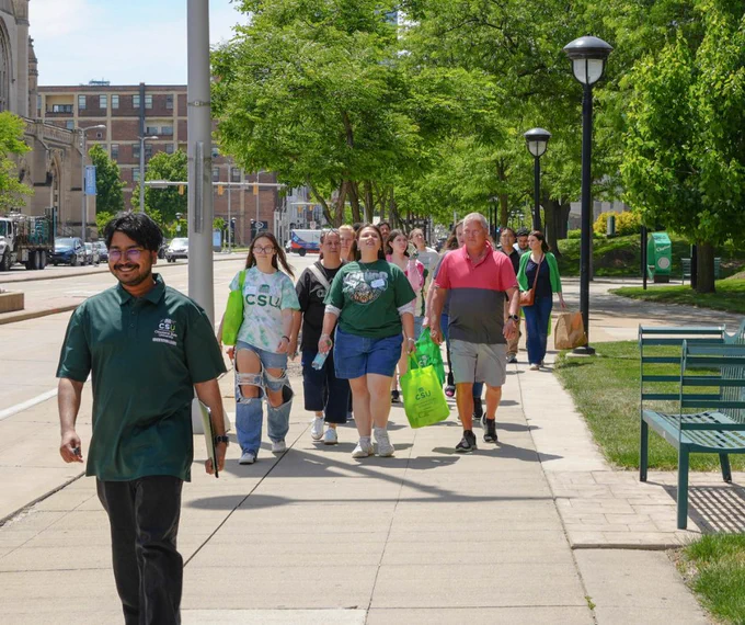 An orientation leader giving a group of new CSU students and their families a tour of campus.