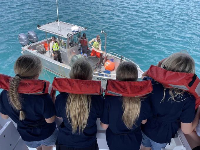 Students viewing a live lake sturgeon during a boat cruise on the St. Clair River and Lake Huron. Credit: GLFC.
