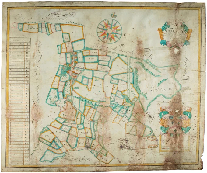 Historic hand-drawn estate map showing irregularly shaped land plots in colour, with a compass rose, decorative cartouches, and a legend listing field names and plot numbers.