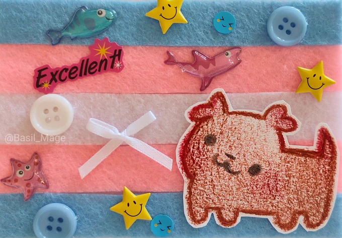 Cutout of a puppy drawing with a felt background of the transgender flag decorated with stickers