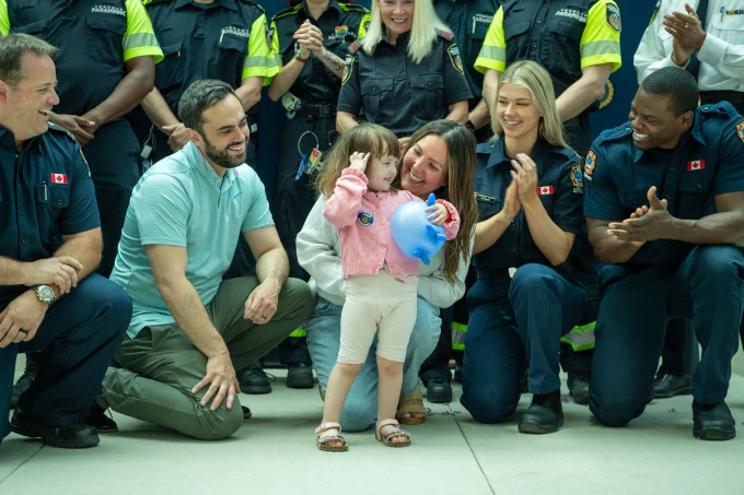 Group photo of emergency responders and a family with a young child.