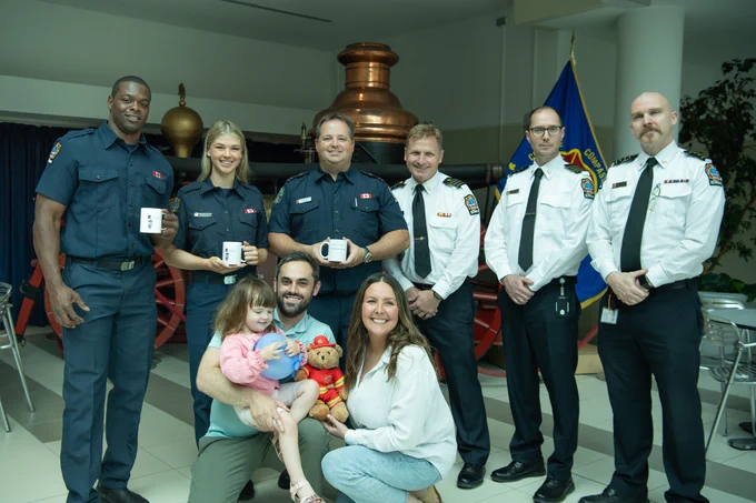 Group photo of emergency responders and a family with a young child.
