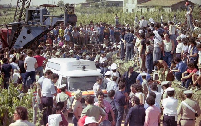 Foto d'epoca: grande folla di soccorritori, giornalisti e civili radunata attorno al sito di scavo durante la tragedia di Vermicino.