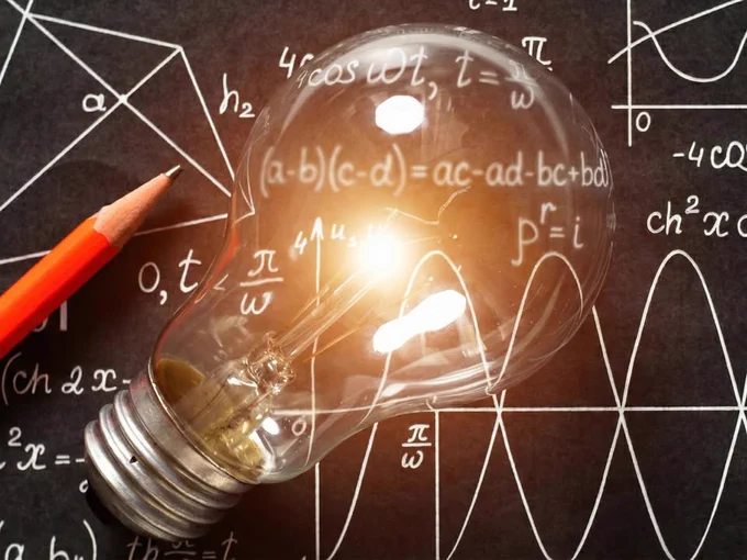 A light bulb lies on a blackboard covered with mathematical formulas and equations, illuminated in a bright glow, with a red pencil beside it.