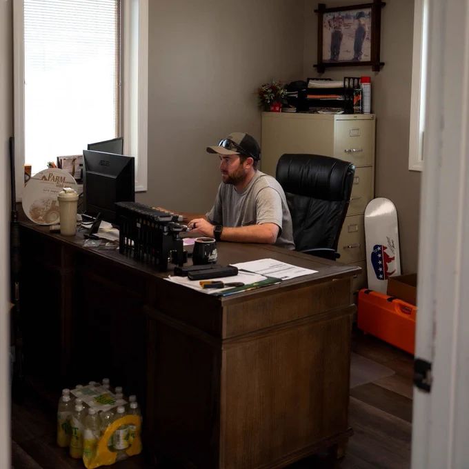 Farmer sitting at his desk and working on his computer. 