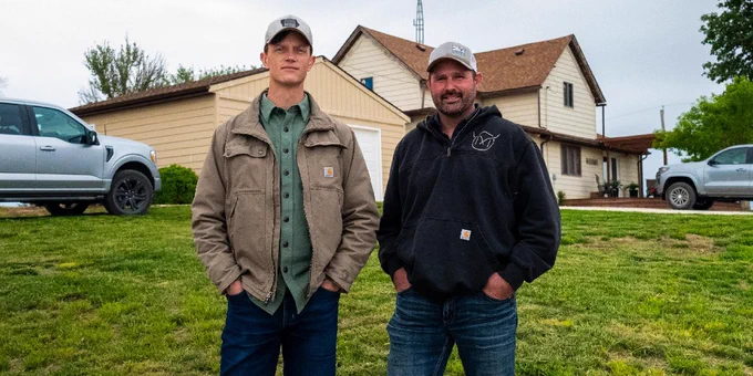 A photo of Rob Sand and his running mate Dave Muhlbauer standing on Dave's farm. 