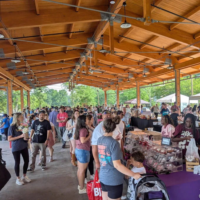 A crowd of shoppers at an outdoor farmers' market.