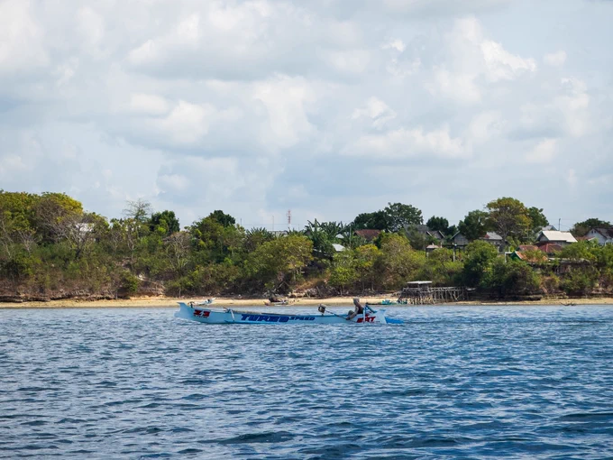 With the gruelling harvest finished, Pak Peri steers his small motorised boat back toward the white sands of his non-touristic island home. His gathered nets sit empty beside him, a quiet moment of exhaustion after hours of fruitless labour on the water.