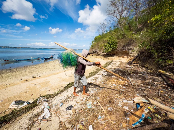 The day is done. Pak Peri walks away from the ocean, framed against the sandy beach as he carries his massive fishing net balanced on a wooden pole across his shoulders. He heads home to his wife and child with almost empty hands, ready to repeat the entire gruelling process tomorrow.