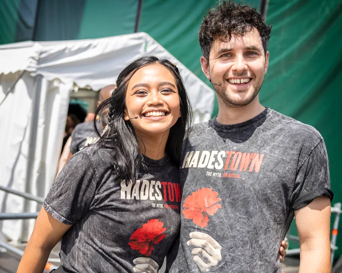 The cast of Hadestown hugging and smiling backstage at West End LIVE.