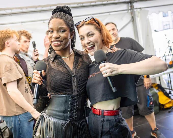 Cast members from Just For One Day - The Live Aid Musical and The Devil Wears Prada hugging and smiling backstage at West End LIVE.