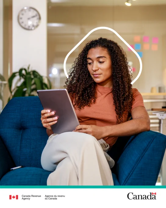 Person seated in an armchair using a tablet. 