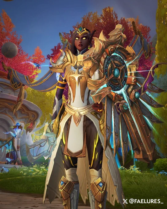 A female blood elf paladin is dressed in golden armor with white cloth accents. She wears a golden tiara with a gemstone in the center resting on her forehead. Her shoulder armor is primarily silver with gold trim. A four-pointed star sits at the center of her chestplate, with a white-and-gold tabard hanging beneath it. The armor features dark sleeves and a long robe that opens in the front. She has [Truthguard] equipped as she stands watch over Silvermoon.