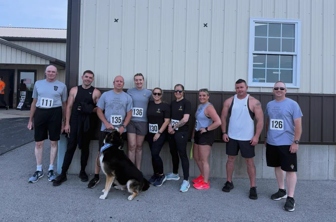 Eight members of the Patrol  stand outside during the 6th Annual Rick Moyer Legacy Foundation Pump n Run/5K. Also with them is a pet dog.
