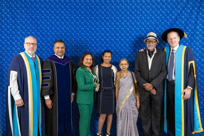 A photo of honorary degree recipient Nitin Jain, President and CEO of Sienna Senior Living, posing for a group photo at Ontario Tech's 2026 Spring Convocation ceremony with Ontario Tech Chancellor Mitch Frazer, Ontario Tech President Steven Murphy and members of his family.
