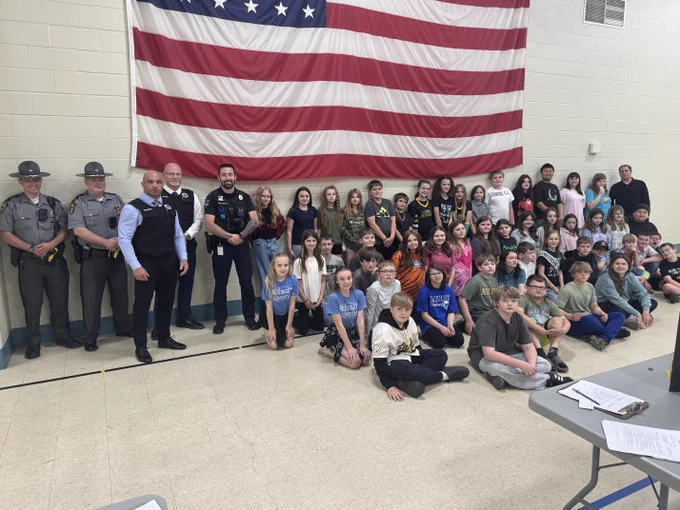 Two troopers (back left) joined law enforcement partners in a group photo with 50 students who participated in the science fair. 