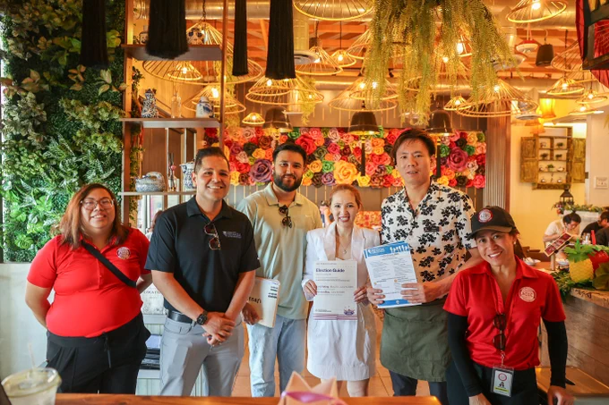 NVSOS and ACDC team pose for picture with business owner inside restaurant