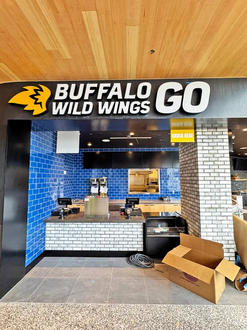 Storefront of Buffalo Wild Wings GO with blue tiled interior and visible counter.