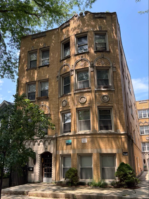 a tan 4-story brick building with intricate decorations on the facade