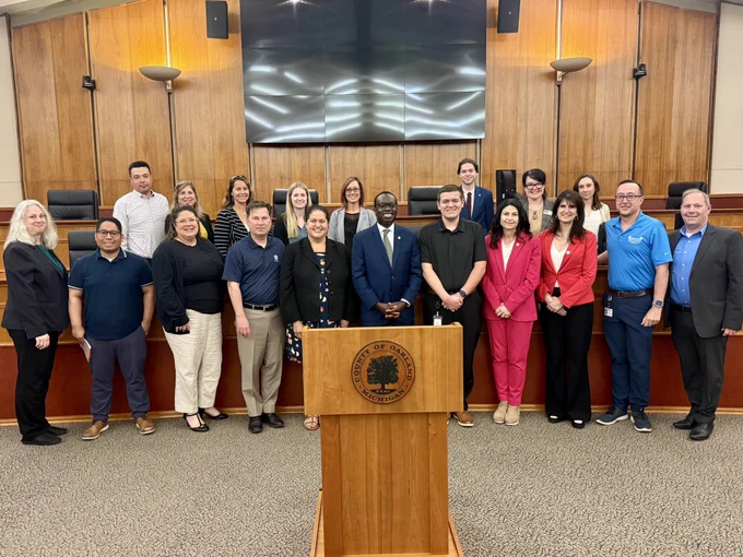 AG Nessel, Deputy SOS Edevbie, and Oakland Co clerks pose for photo in council chambers