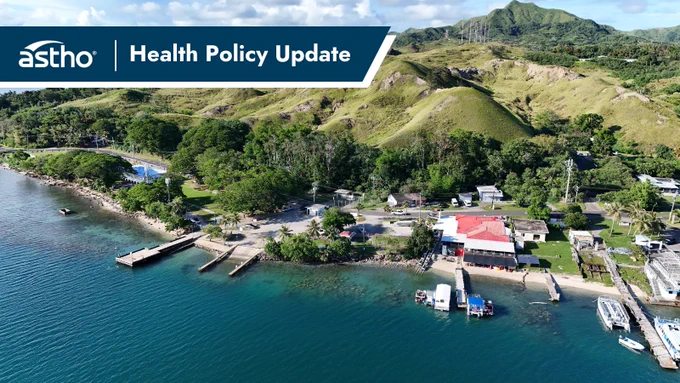 A scenic coastal area with lush greenery and rolling hills, near the shorelines where several small docks and boats are visible. The image features a banner with the text "astho | Health Policy Update" at the top left.