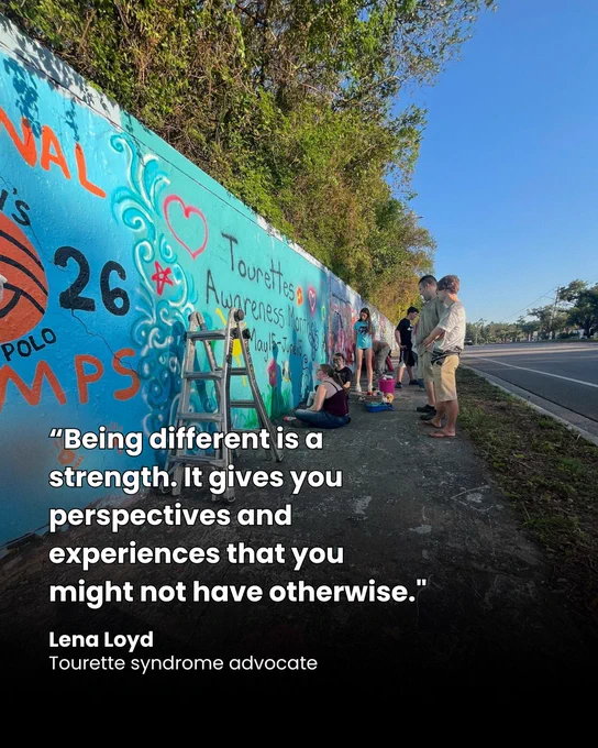 People painting a colorful mural on a long wall beside a road under a clear blue sky. Quote from Lena Loyd "Being different is a strength. It gives you perspectives and experiences that you might not have otherwise."