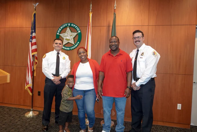 MDFR Lt. Jesus Fuentes, BSO Fire Rescue FF Broderick Espinoza with Tyler Nelson and family.