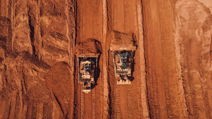 Aerial shot of two tractors excavating red earth, showcasing construction and mining machinery in Brazil.