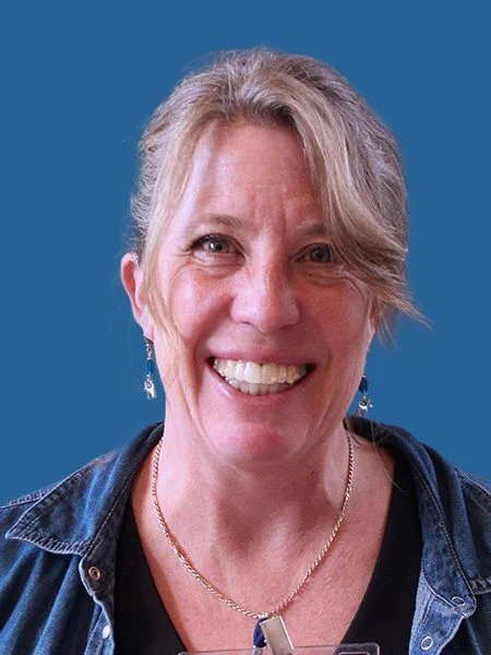 Photograph of Heather Mace with a blue background.