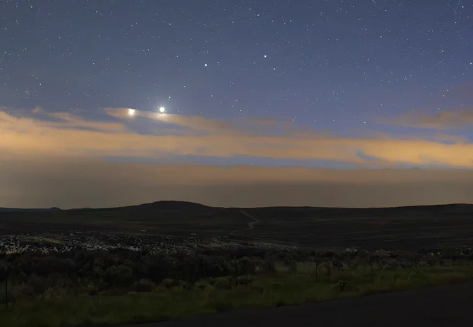 Venus and Jupiter in conjunction, appearing as two brightly glowing stars close together amid clouds. Photo: NASA/Bill Dunford