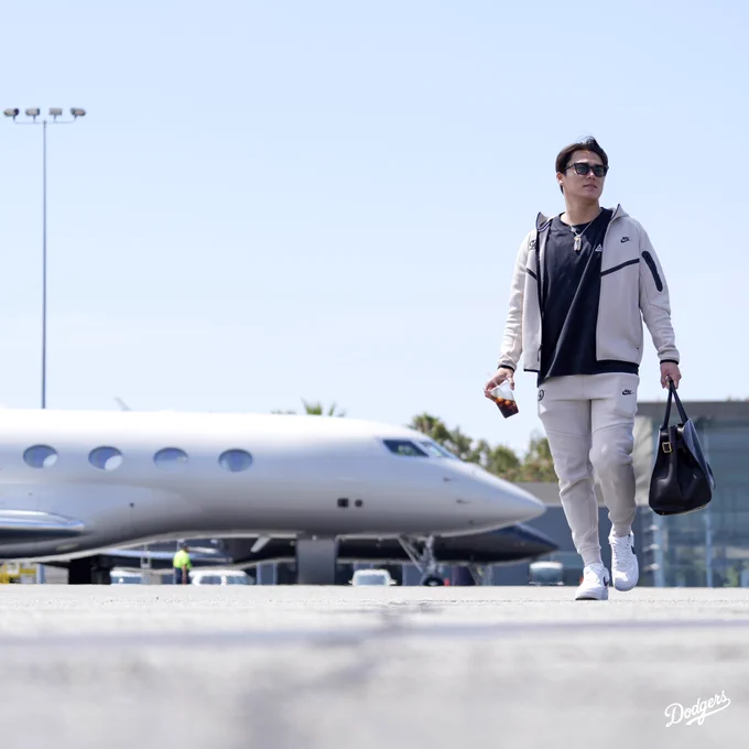 A photo of Yoshinobu Yamamoto walking on the tarmac to the airplane.