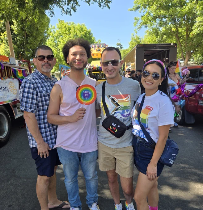 Staff and alumni attending Fresno Pride in colorful clothing under sunny skies.