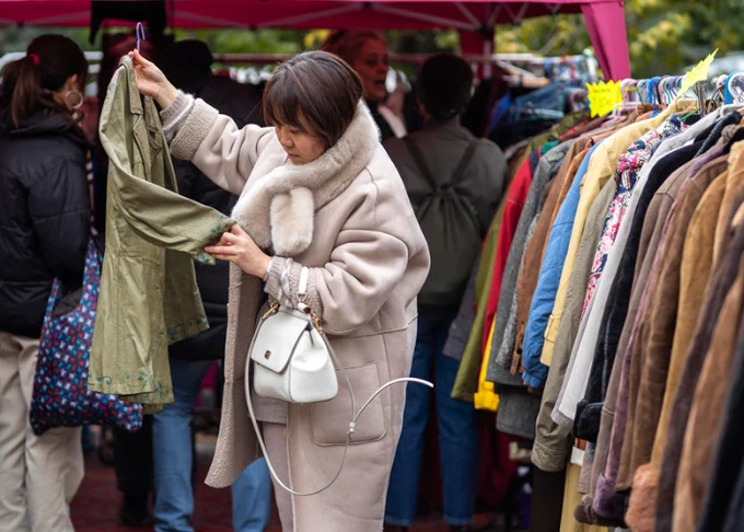Persona delante de un puesto de ropa 