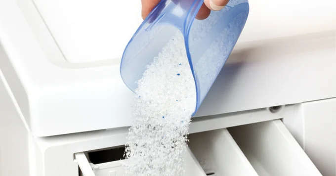 Person add washing powder to washing machine