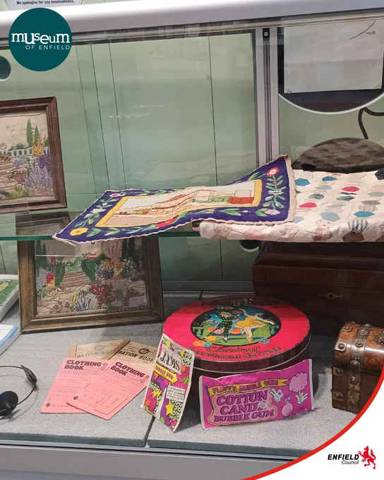 A photograph of a museum display case filled with artwork and objects
