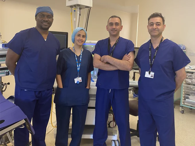Four consultants dressed in scrubs in a theatre 