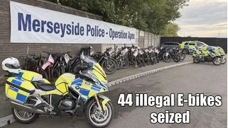 Merseyside Police display 44 seized illegal e-bikes alongside police motorcycles and a car.