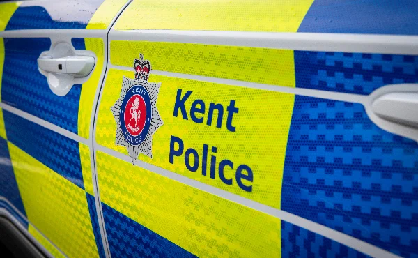 A close-up of the Kent Police logo and crest on a police car.