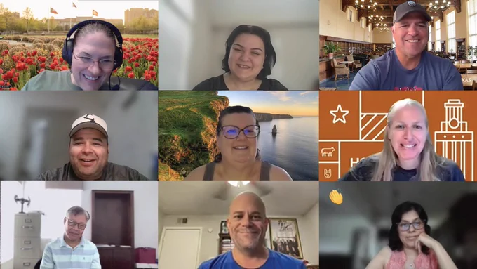 Grid of nine people in a virtual meeting, each in a separate video tile with different home or virtual backgrounds, including flowers, a library, a coastal landscape, and a branded orange backdrop.