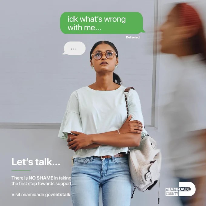 A young woman with dark hair, glasses, and a nose ring stands with crossed arms, looking up thoughtfully. Above her, a green text bubble says \"idk what's wrong with me...\" with a smaller bubble nearby. Text reads: \"Let's talk... There is NO SHAME in taking the first step towards support. Visit miamidade.gov/letstalk.\" Miami-Dade County logo.