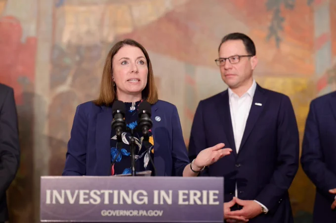 Erie Mayor Daria S. Devlin speaks from a podium with Governor Josh Shapiro standing behind her.