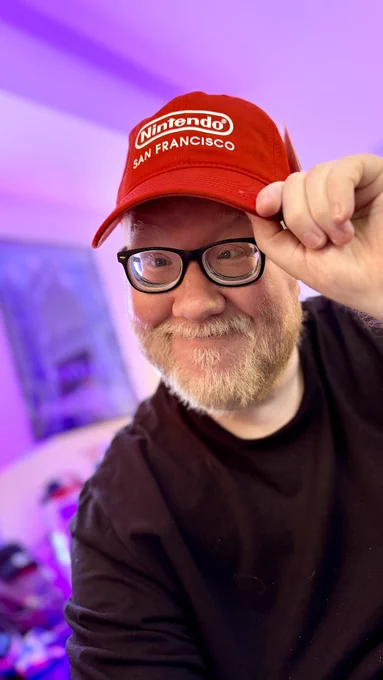 Selfie of me wearing a bright red Nintendo San Francisco hat
