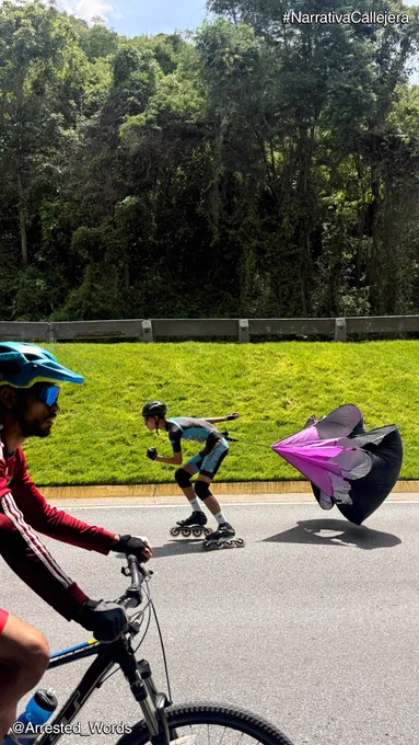 En primer plano un ciclista con su casco y anteojos, en la calle detrás un patinador con un paracaídas para frenar. Al fondo bosque.

Texto arriba: #NarrativaCallejera
Texto abajo: @Arrested_Words