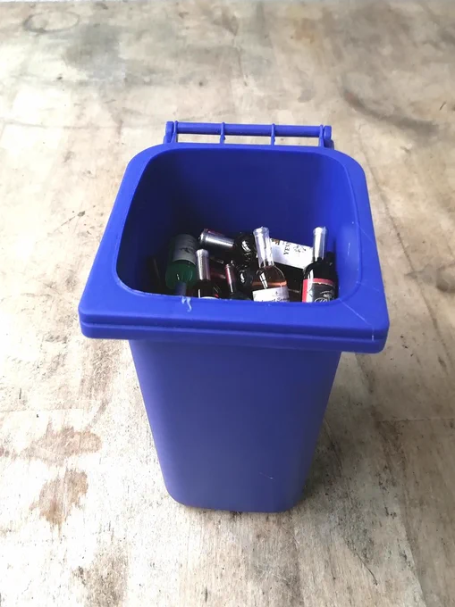 Bin the Booze 2: A blue plastic bin with bottles of liquid of various colours.